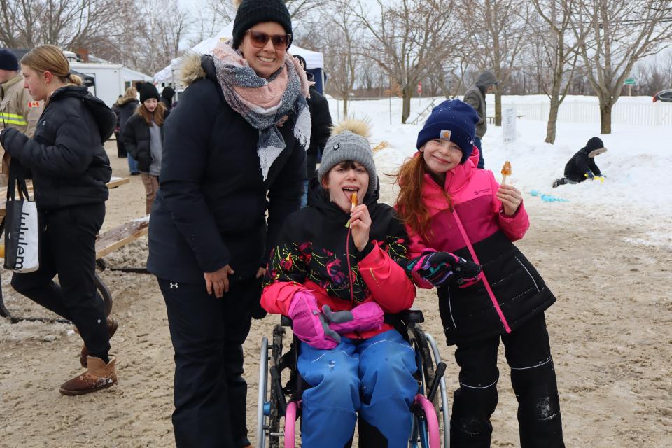 Mom and daughters enjoying maple taffy